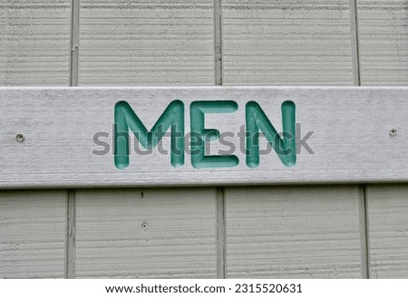 A close view of the wood board men restroom sign.