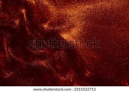Abstract shiny glittering background. Magic Galaxy of golden dust particles in red fluid. Glittering particles of gold dust in a swirl of red liquid. Royalty-Free Stock Photo #2315522713