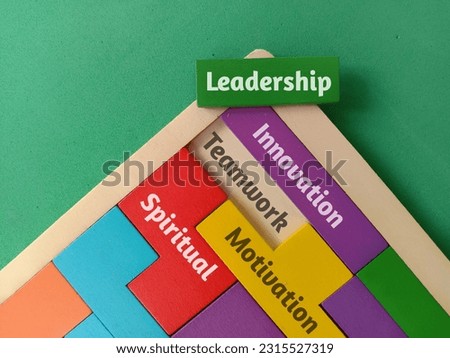 Concept image wooden puzzle with word TEAMWORK, LEADERSHIP, MOTIVATION, INNOVATION, SPIRITUAL on green background .Business and education concept.