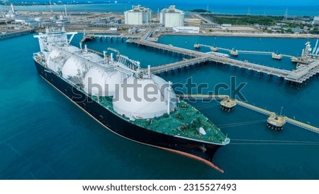 LNG (Liquified Natural Gas) tanker anchored in Gas terminal gas tanks for storage. Oil Crude Gas Tanker Ship. LPG at Tanker Bay Petroleum Chemical or Methane freighter export import transportation  Royalty-Free Stock Photo #2315527493