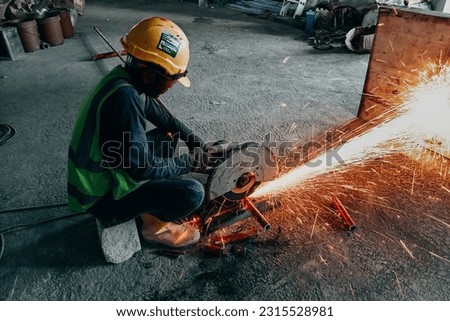 picture of worker cutting metal pipe with  metal cutting mechine