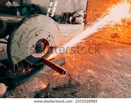 picture of worker cutting metal pipe with  metal cutting mechine