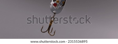 Fishing tackle with bait and hook on gray background