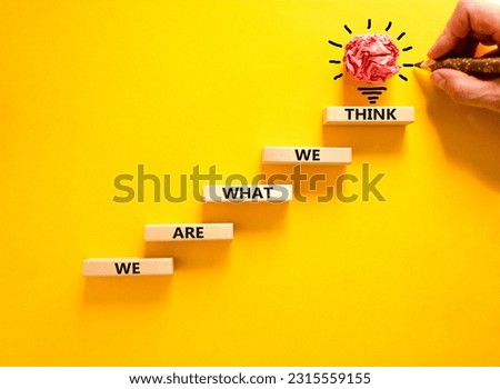 We are what we think symbol. Concept word We are what we think on wooden block. Beautiful yellow table yellow background. Businessman hand. Business We are what we think concept. Copy space.