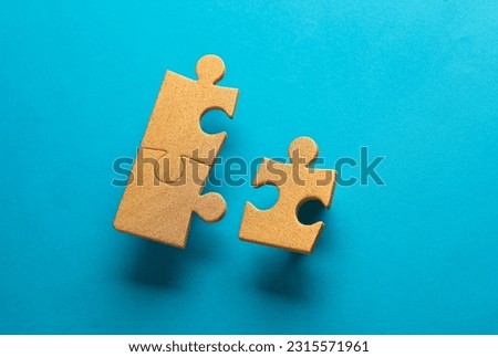 Golden jigsaw puzzle particles on blue background. Business concept