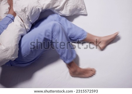 Man With RLS - Restless Legs Syndrome. Sleeping In Bed Royalty-Free Stock Photo #2315572593