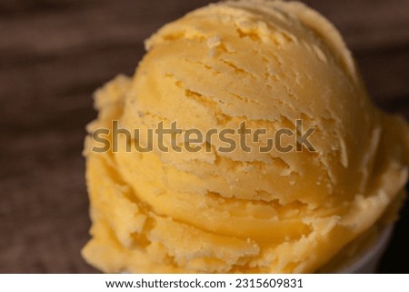 Tasty yellow scoop of ice cream. Close-up photography with blurred background.