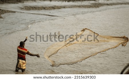 A bangladeshi fisherman is fishing in the meghna river