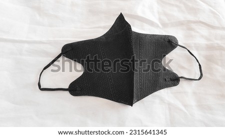 A surgical mask with a rubber earpiece. A typical 3-layer surgical mask covering the mouth and nose. Bacteria mask procedure. The concept of protection.