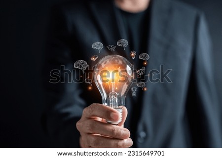 Man holding illuminated lightbulb glowing to Starting New idea, innovation and inspiration, smart intelligent creativity, Motivation and innovation concept. Royalty-Free Stock Photo #2315649701