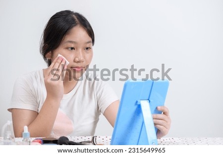 Cute asian girl uses cotton pad with toner for cleaning make up feeling so fresh and clean with healthy skin, isolated on white background. Royalty-Free Stock Photo #2315649965
