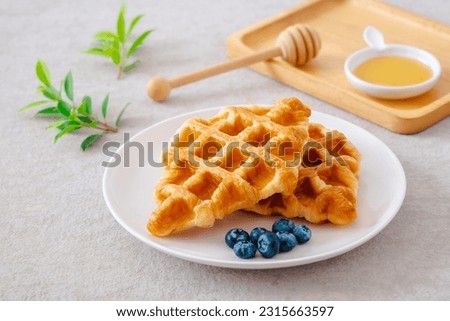 Croffle or croissant waffle with blueberries on plate Royalty-Free Stock Photo #2315663597