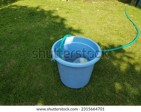 Blue bucket on grass background.