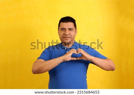 Dark-haired 40-year-old Latino man shows Mexican sign language used to communicate between the deaf and dumb Royalty-Free Stock Photo #2315684653