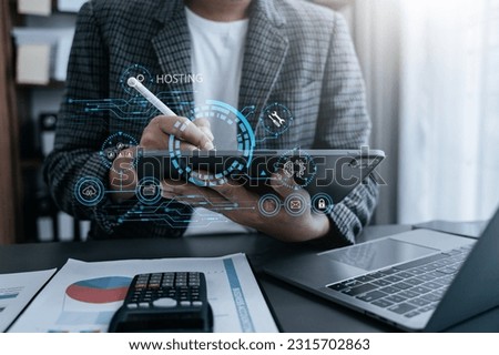 Male using computer, tablet and presses his finger on the virtual screen inscription Hosting on desk, Web hosting concept, Internet, business, digital technology concept.