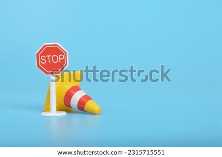 Plastic traffic cone and stop sign. Copy space for the text.