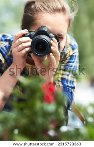 Woman, camera and photography in nature for flower, plant and growth in garden, park and summer sunshine. Girl, photographer and travel in countryside with red flowers, memory and outdoor with leaves