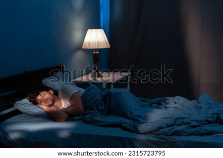 Young arabic man sleeping in bed at home at night. People, bedtime and rest concept. Copy space Royalty-Free Stock Photo #2315723795