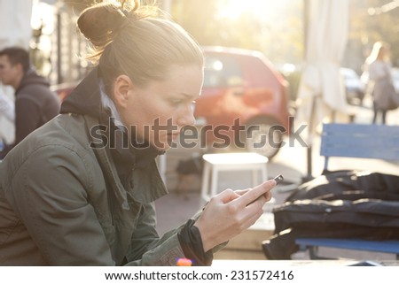 Woman Sitting In Cafe Bar And Using A Mobile Phon