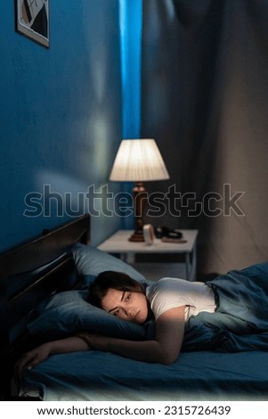 Woman suffering from insomnia lying in bed with open eyes. Girl in bed sleep disorder thinking about problems at night. Copy space Royalty-Free Stock Photo #2315726439