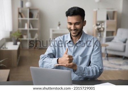Positive sign language therapist speaking with gestures on video call. Communication expert talking to patient, student with hearing disability, showing like, thumb up gesture on palm at computer Royalty-Free Stock Photo #2315729001