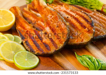 Delicious  portion of fresh salmon fillet with lime cooked on a grill or BBQ