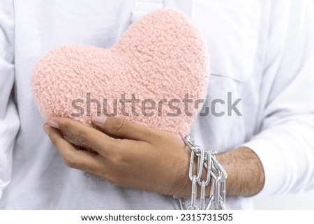 Male hand holding an unchained heart