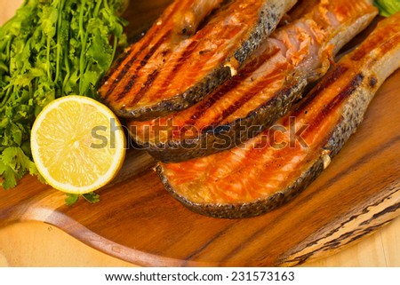 Delicious  portion of fresh salmon fillet with lime cooked on a grill or BBQ