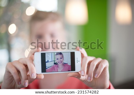 beautiful young woman taking a Selfie with her smartphone, close up on the phone screen