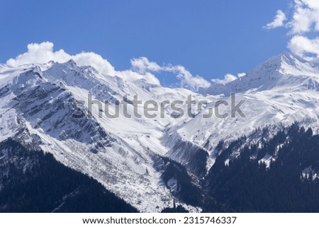Snow capped and forested mountains with at Tosh Royalty-Free Stock Photo #2315746337
