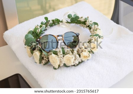 bridal wreath made of natural flowers and sunglasses on a towel in a spa Royalty-Free Stock Photo #2315765617