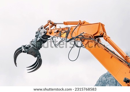 heavy machinery manipulator for logs at a sawmill or heavy cargo transfer Royalty-Free Stock Photo #2315768583
