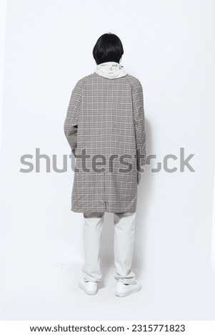Full body back view portrait of handsome male  wearing striped, long coat posing on white background Royalty-Free Stock Photo #2315771823