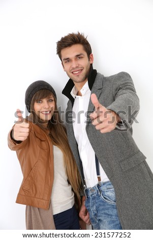 Trendy couple showing thumbs up, isolated