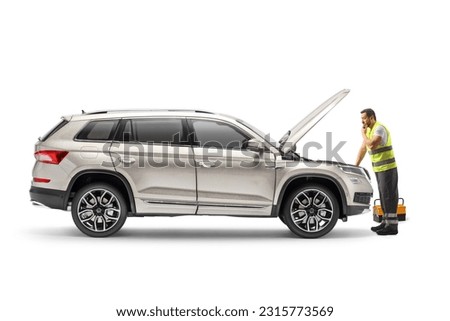 Road assistance agent repairing a SUV isolated on white background Royalty-Free Stock Photo #2315773569