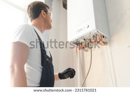 Professional plumber checking a boiler and pipes, boiler service concept. Royalty-Free Stock Photo #2315781021