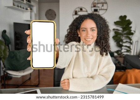 Latin young woman student holding mobile phone in hand using elearning app on cell showing white big blank cellular display mock up, smartphone mockup screen for advertising.