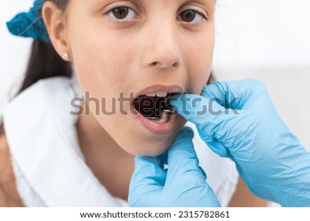 Dentist is check and set dimension of brackets. Talking to girl about braces in her mouth Royalty-Free Stock Photo #2315782861