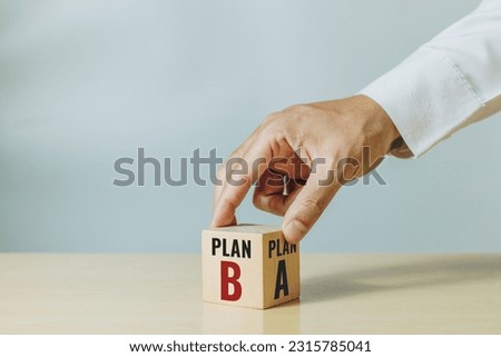 Hand choose wooden with the word PLAN A to PLAN B on green background. Business concept Royalty-Free Stock Photo #2315785041