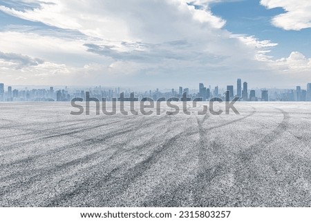 Empty asphalt road and city buildings skyline