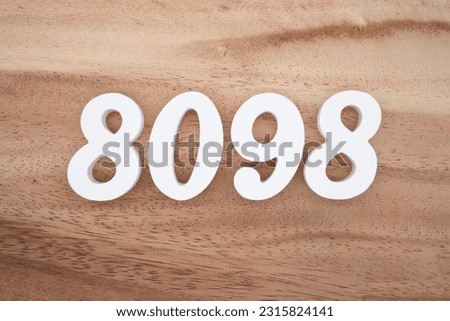 White number 8098 on a brown and light brown wooden background.