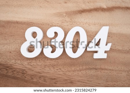 White number 8304 on a brown and light brown wooden background.