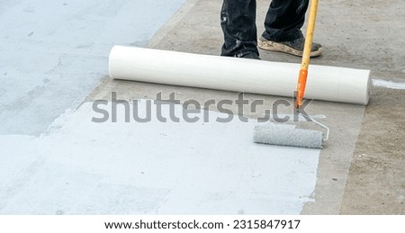 Hand painted gray flooring with paint rollers for waterproof, reinforcing net,Repairing waterproofing deck flooring. roof.                 Royalty-Free Stock Photo #2315847917