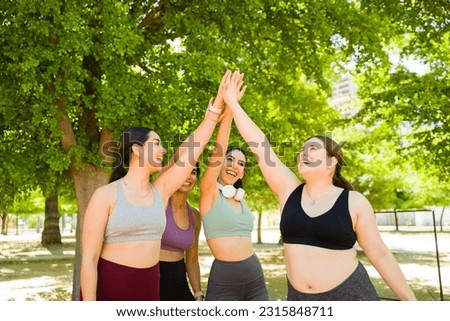 Excited group of diverse women doing a high five celebrating finishing their run together or exercises promoting body acceptance  Royalty-Free Stock Photo #2315848711