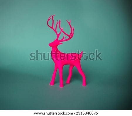 Printed figure of a pink deer on a green background.