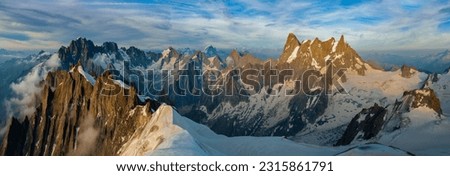 A panoramic view of the peaks and glaciers of the Mont Blanc massif at sunset. Royalty-Free Stock Photo #2315861791