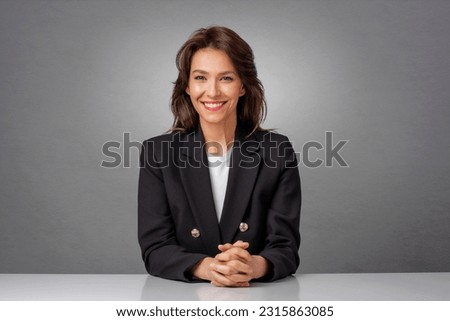 Attractive brunette haired businesswoman wearing blazer and sitting at isolated background. Copy space.
 Royalty-Free Stock Photo #2315863085