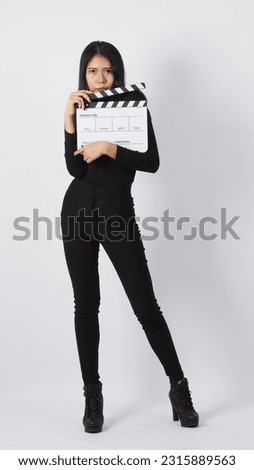 Asian woman full-length body is holding white clapper board on white background.