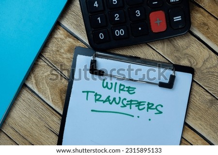Concept of Wire Transfers write on paperwork isolated on Wooden Table.