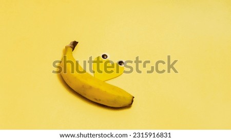 Banner with smiling emoticons and a banana with eyes. Text space, on a yellow background, concept of happiest day of the year, happy yellow day, summer.